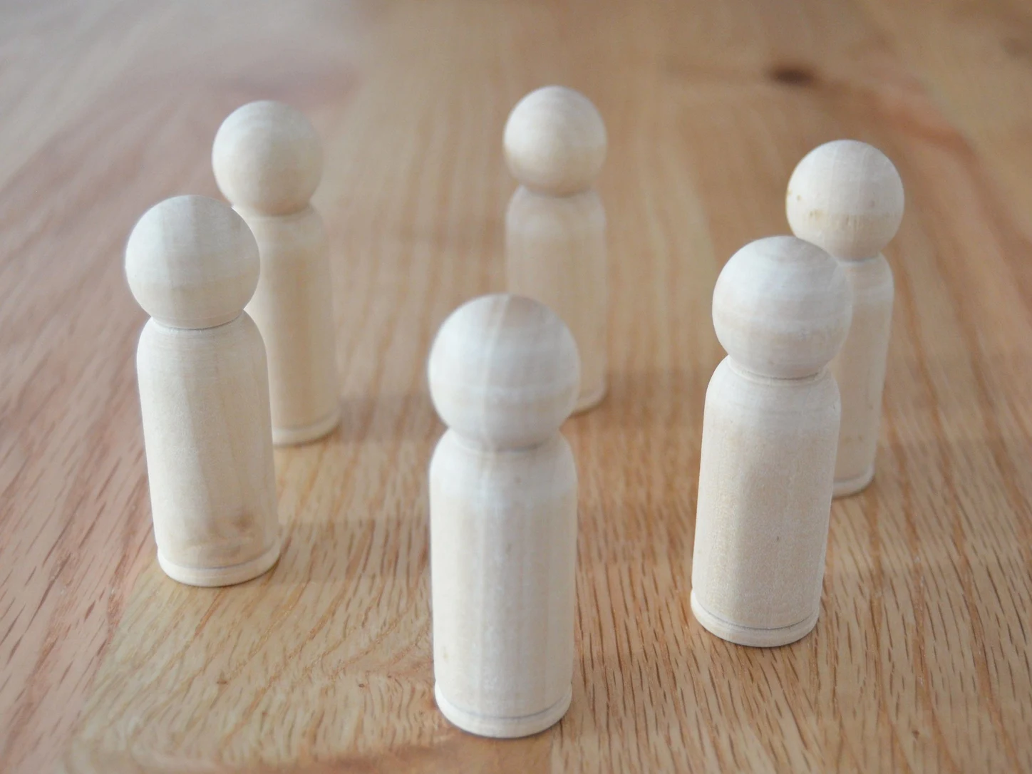 Symbolbild: mehrere Holzfiguren stehen in einer Gruppe beieinander